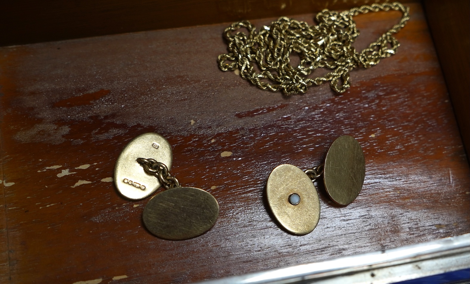 A pair of 9ct gold and seed pearl cufflinks, each end of oval outline, two accented with half pearls, to chain link connections, each end 1.9 x 1.3cm, British hallmarks, date letter for 1991, gross weight approximately 9